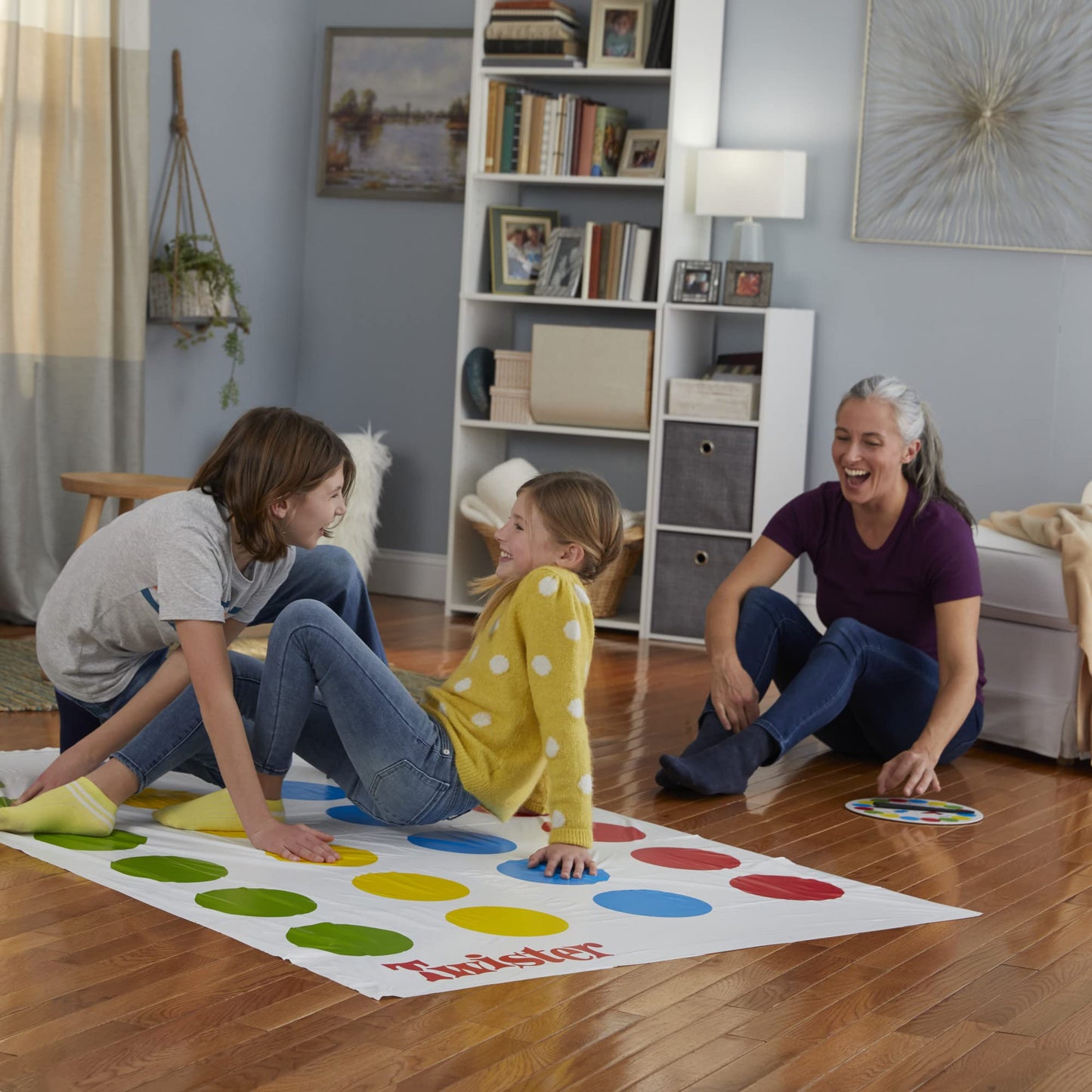Personas jugando a Twister sobre el tapete de colores