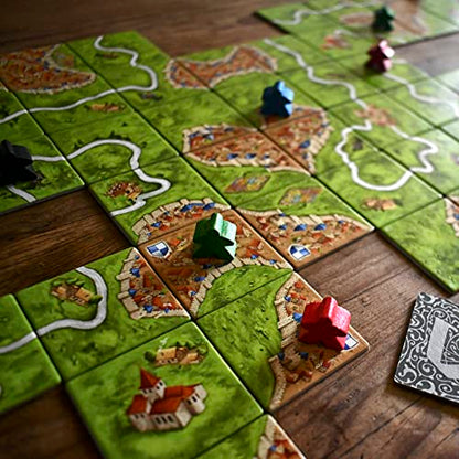 Losetas del juego de mesa Carcassonne con diseños de ciudades, caminos y campos