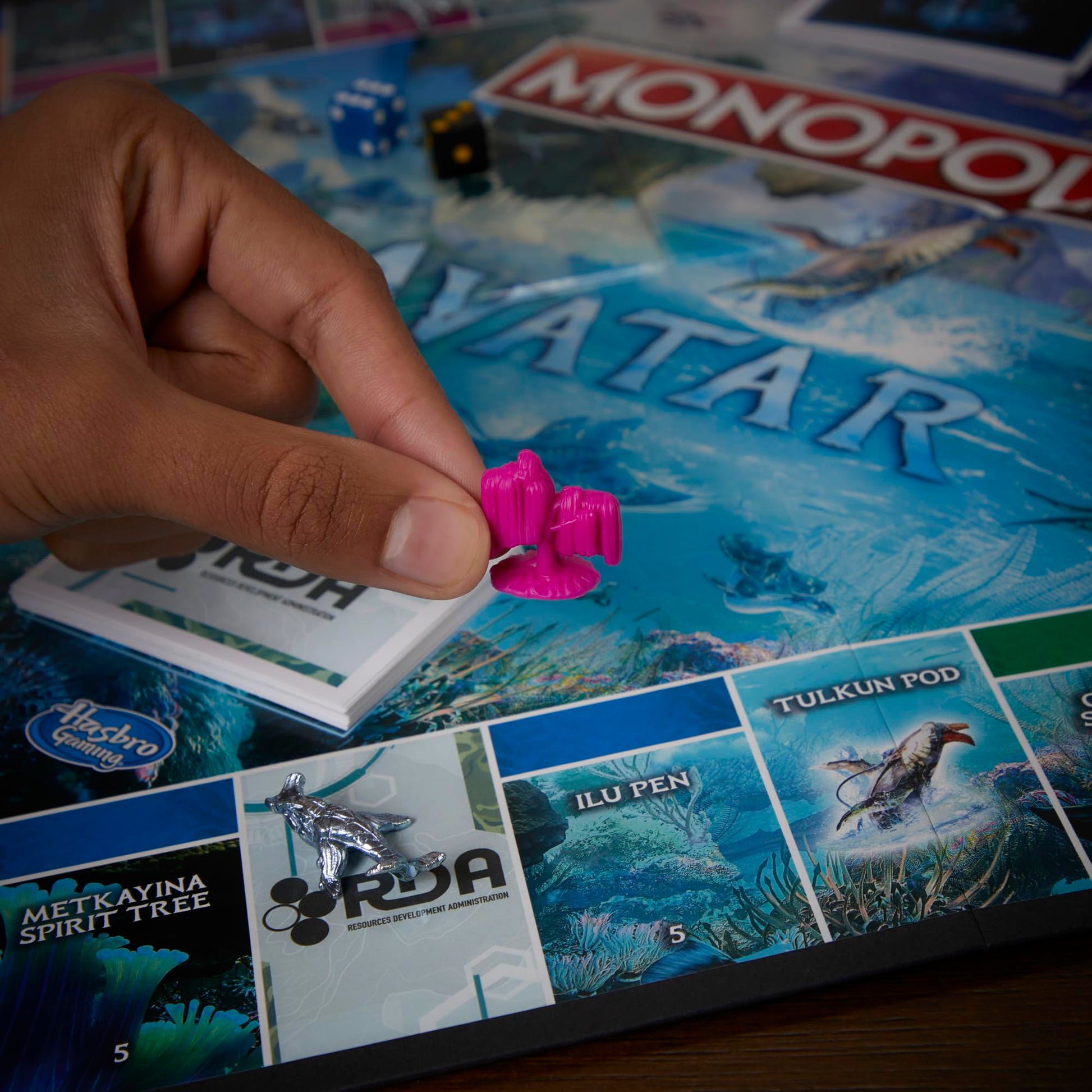 Jugadores disfrutando una partida de Monopoly Avatar alrededor del tablero